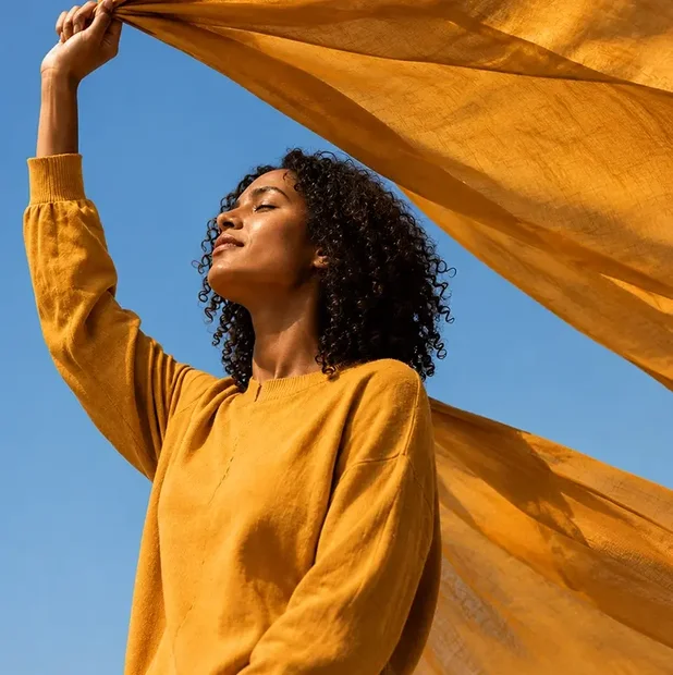 a woman wearing a flowy dress and a fabric waving in the air